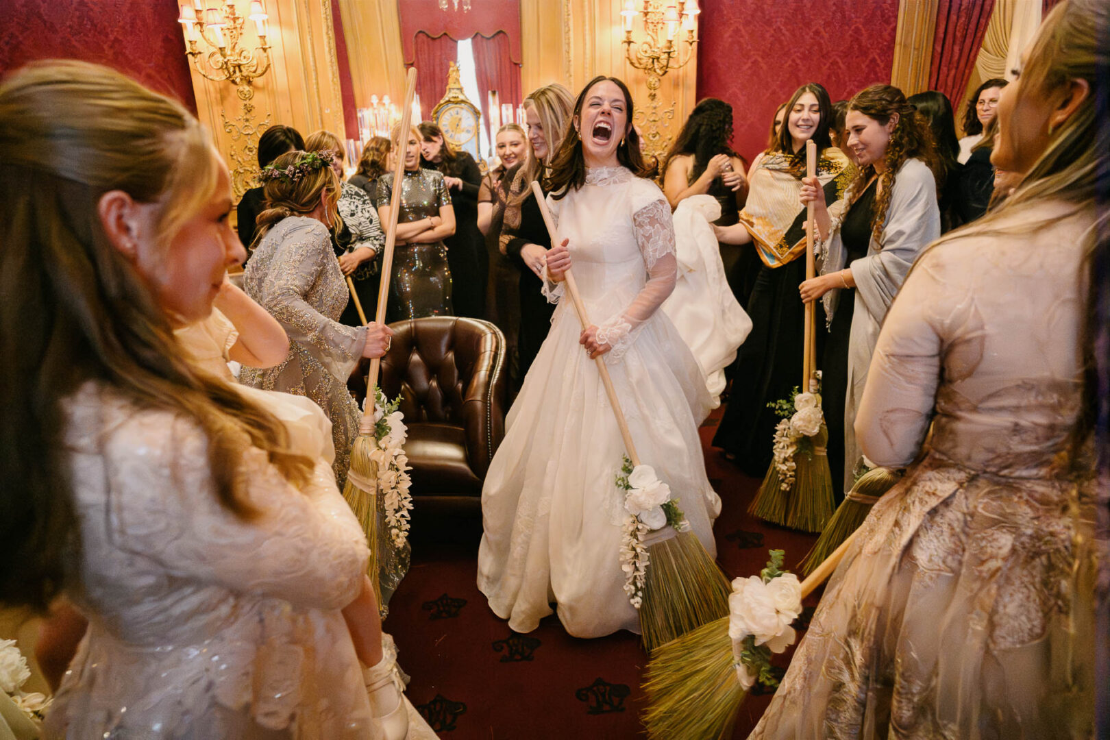 Bride celebrating with friends and brooms.