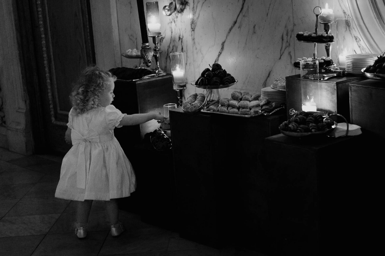 Child reaching for dessert table