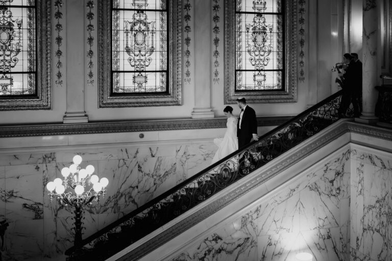 Couple descend staircase with musicians behind them at Metropolitan Club Wedding in New York City