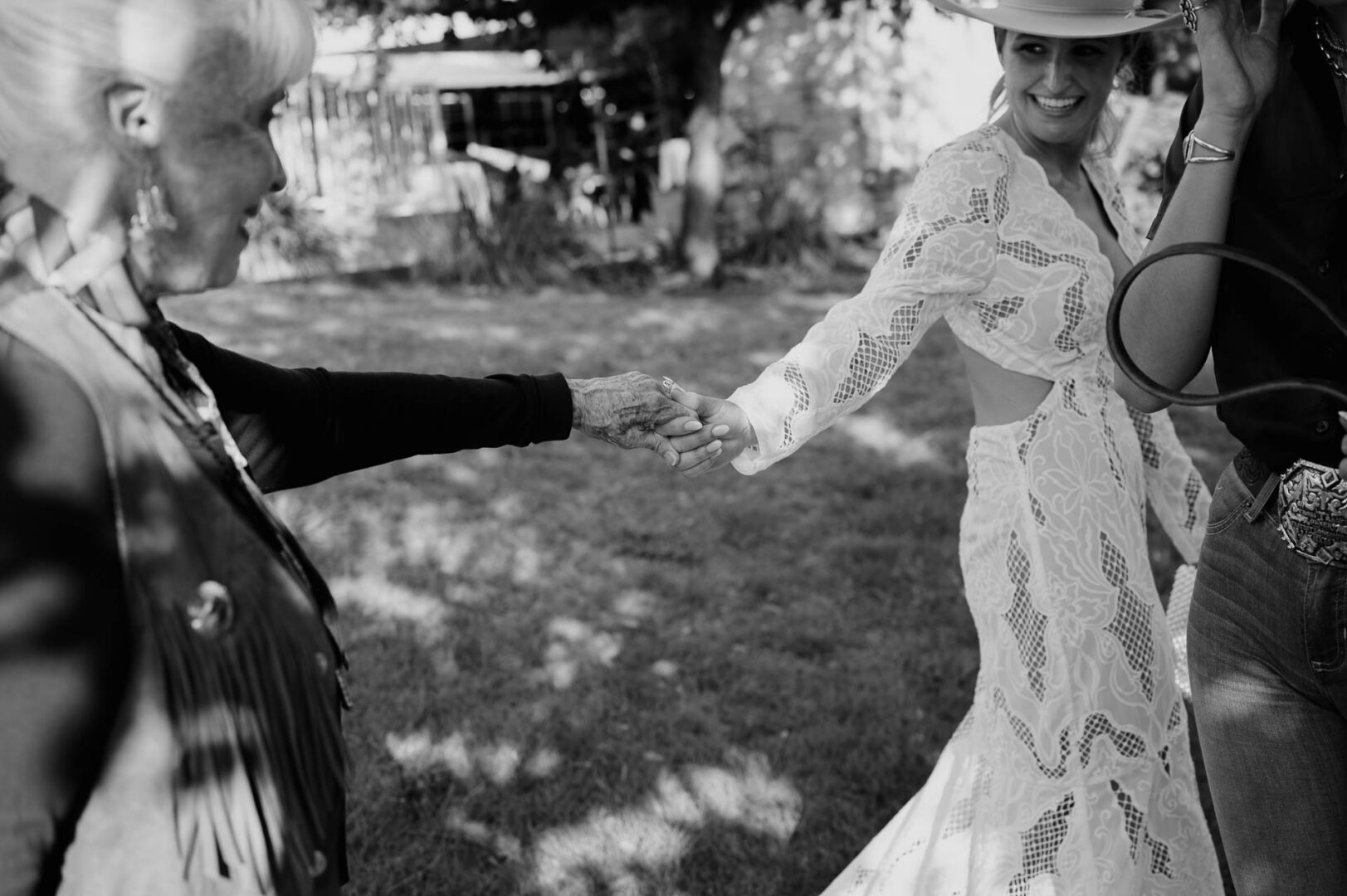 Black-and-white image of the bride and grandma holding hands