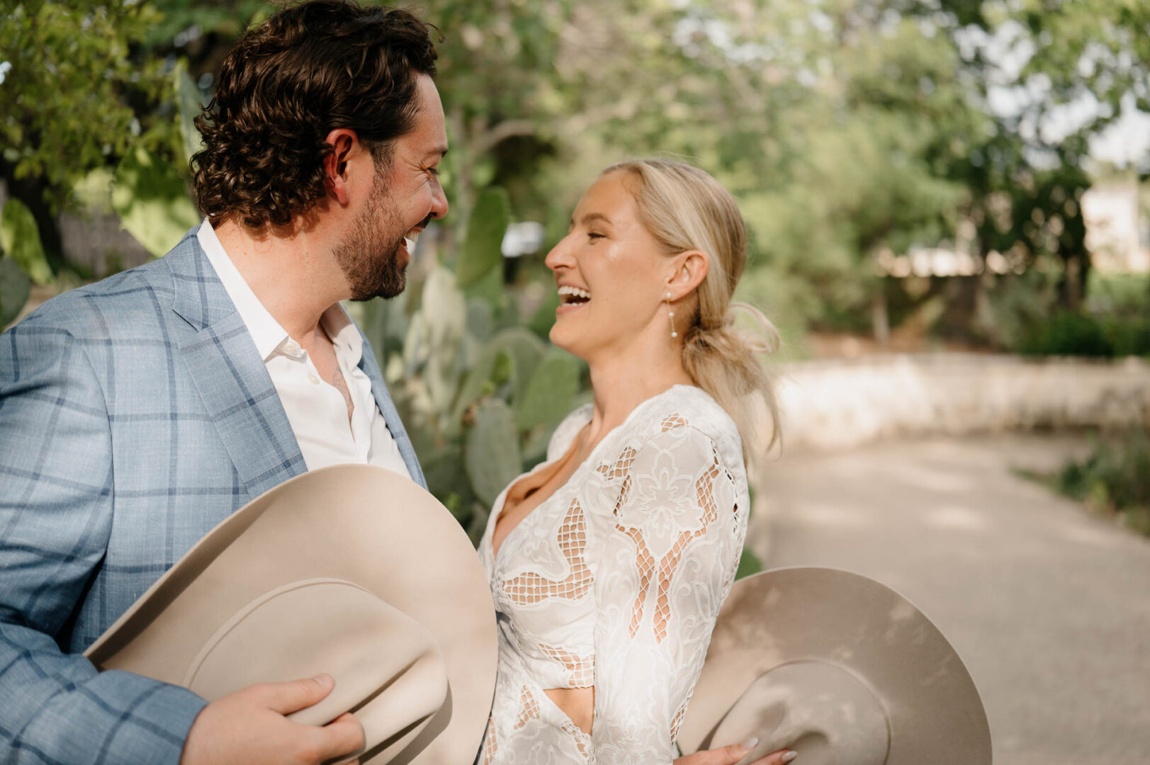 Bride and groom laughing together during portraits on the grounds of The Kendall.