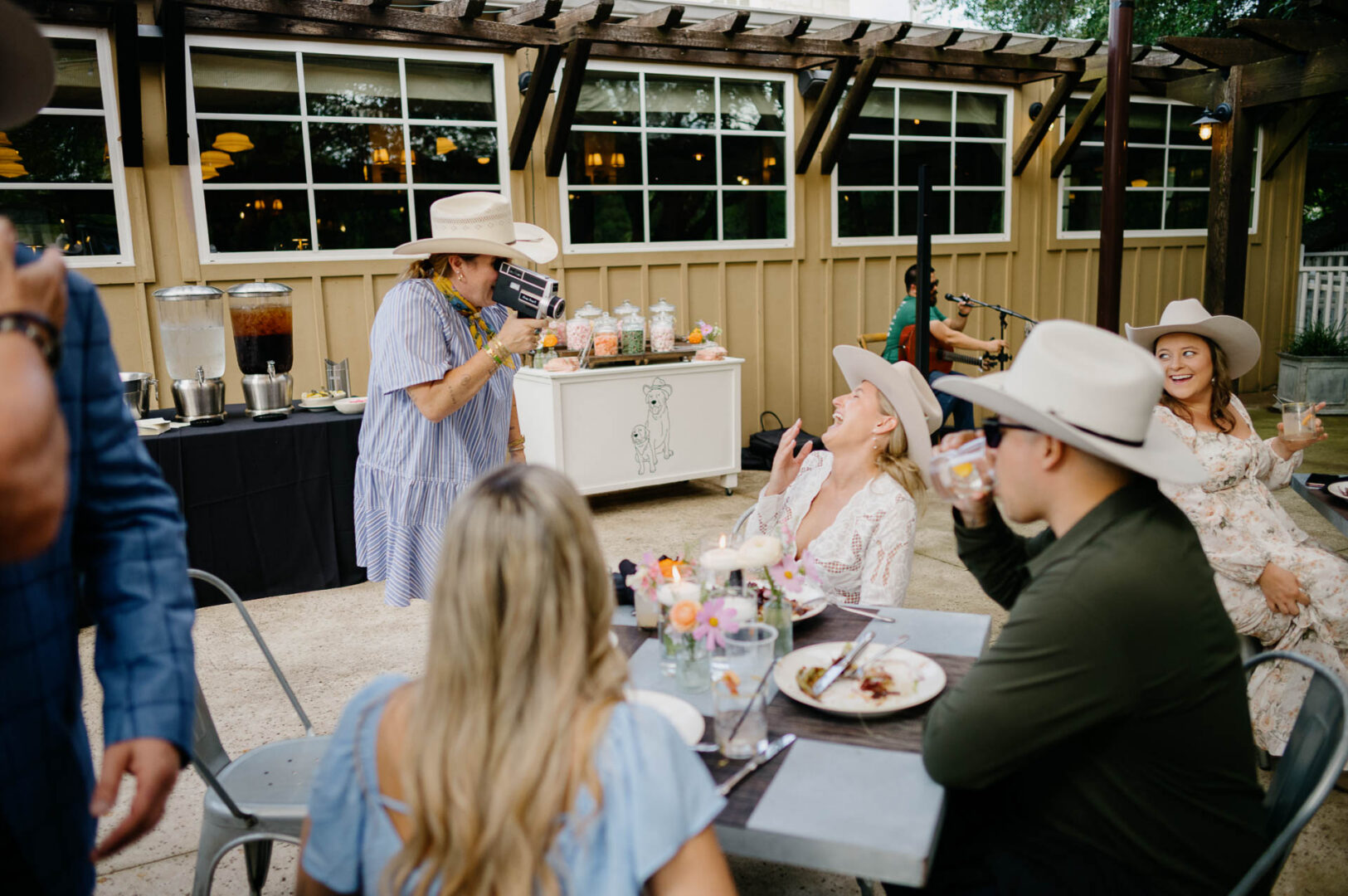Groom in a cowboy videoing guests during the wedding celebration at The Kendall.
