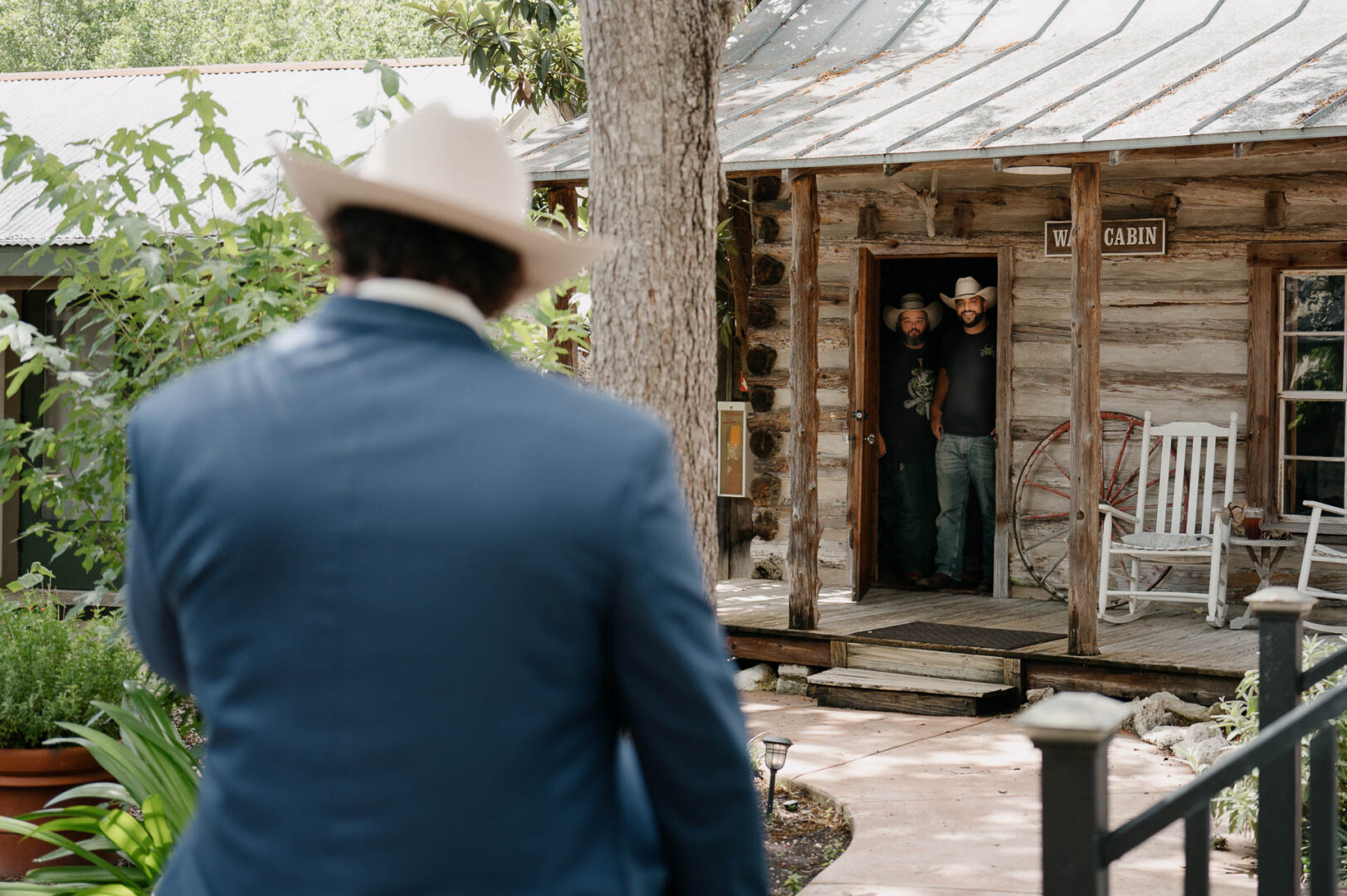 Groom seen from behind before entering a rustic building at The Kendall.