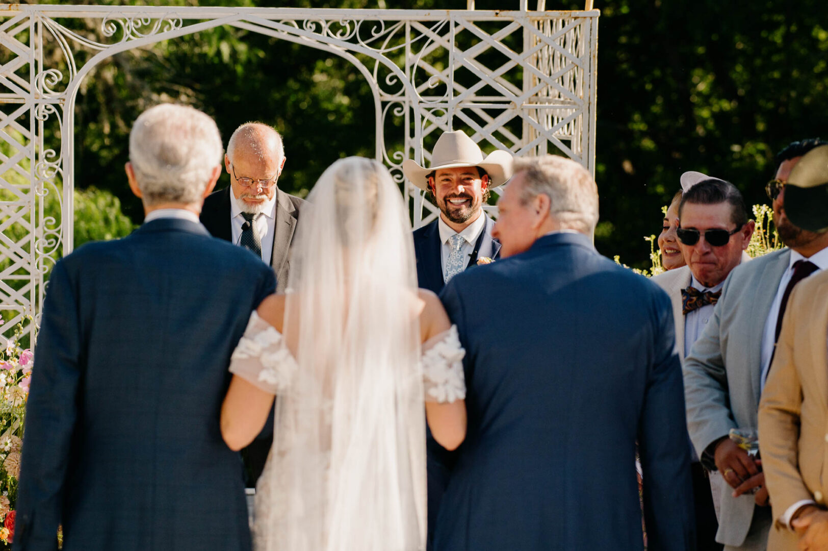 Bride and groom standing with officiant during their ceremony at The Kendall.