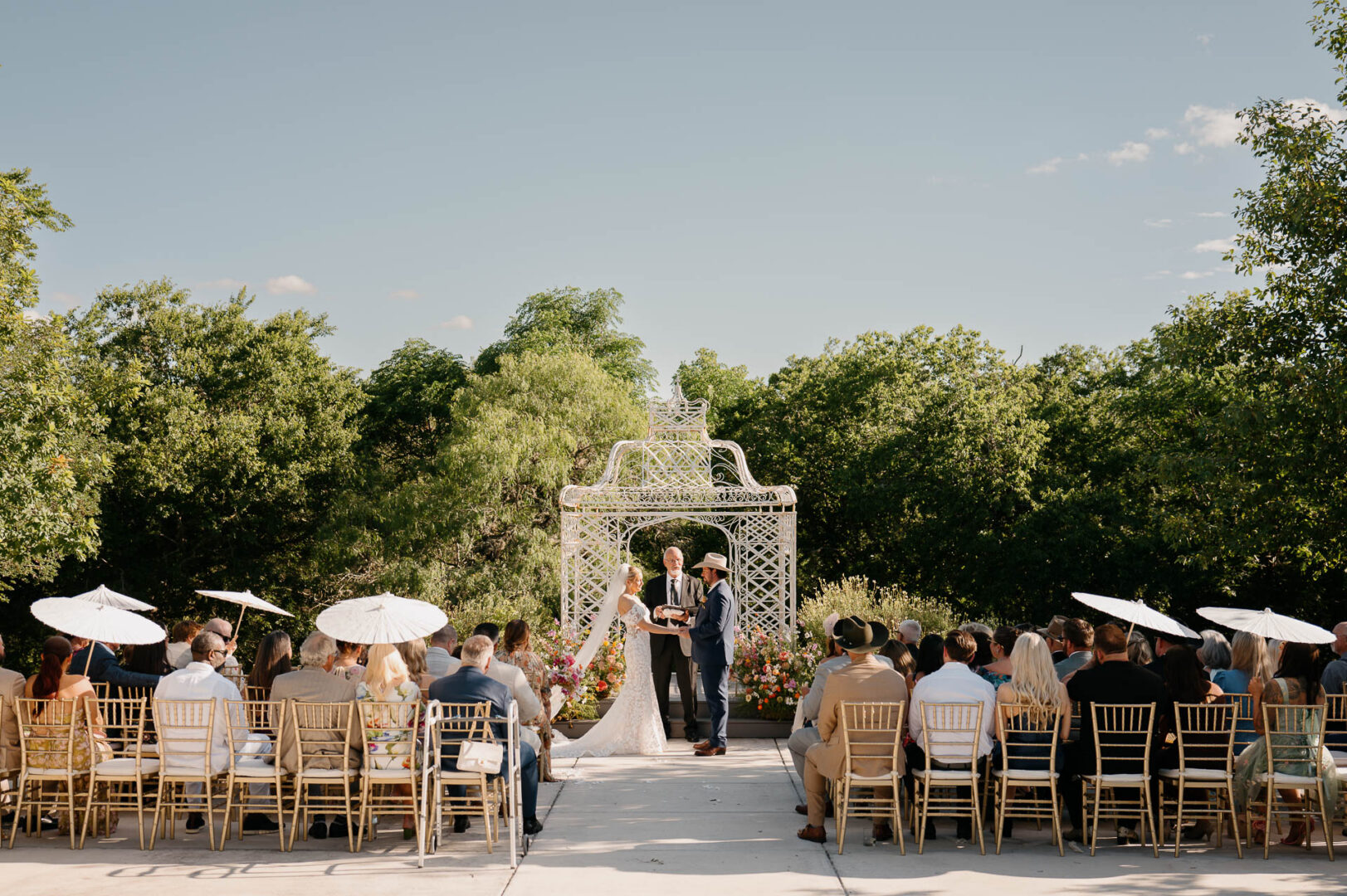 Wide view of the outdoor wedding ceremony beneath trees at The Kendall.