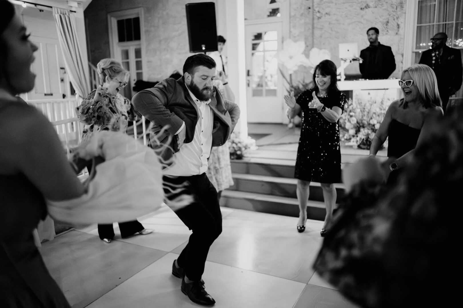 Black-and-white candid of guests dancing during the wedding reception.