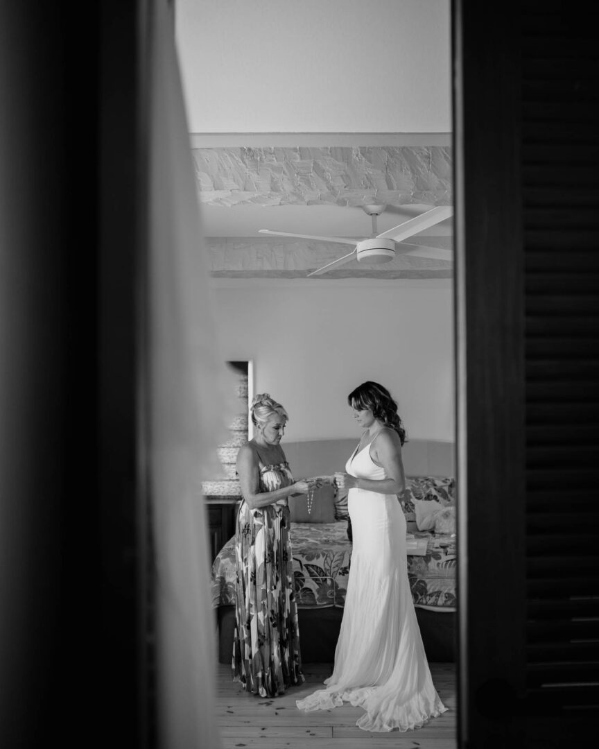 Chapel on the Dunes Wedding | Port Aransas, Texas | Mady+Roland 14 Black-and-white silhouette of a groomsman getting ready near a doorway.