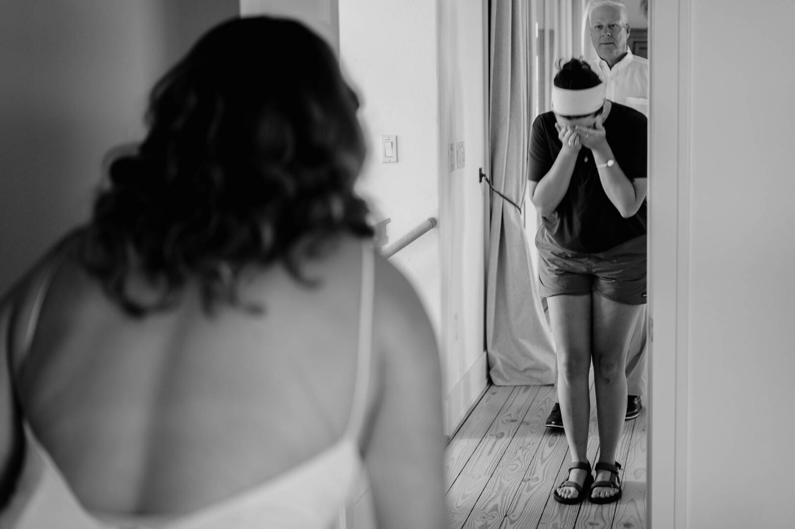 Chapel on the Dunes Wedding | Port Aransas, Texas | Mady+Roland 15 Black-and-white candid from behind of the bride's curly hair, with a friend covering her face in the background.