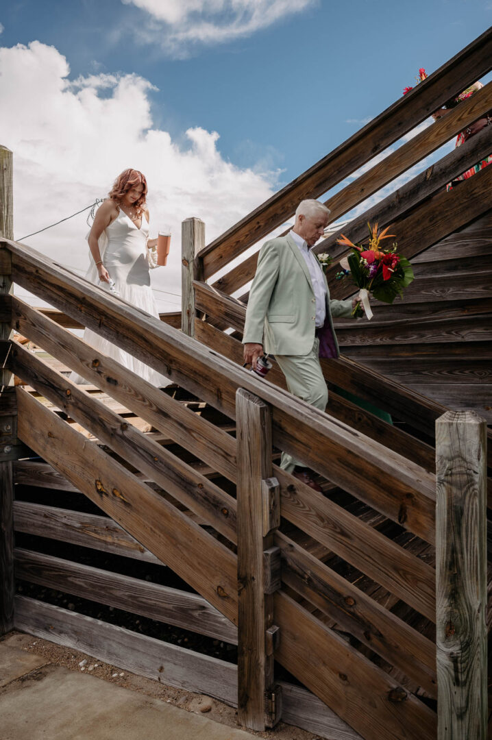 Chapel on the Dunes Wedding | Port Aransas, Texas | Mady+Roland 22 The bride walks down wooden stairs as father of the bride walks below in a coastal, tropical setting.