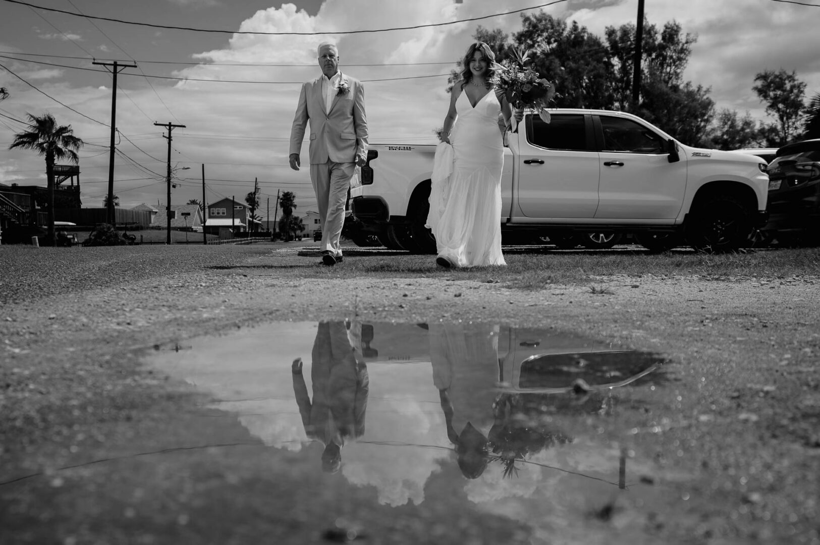 Chapel on the Dunes Wedding | Port Aransas, Texas | Mady+Roland 23 Black-and-white image of father of the bride and bride walking reflection from morning showers
