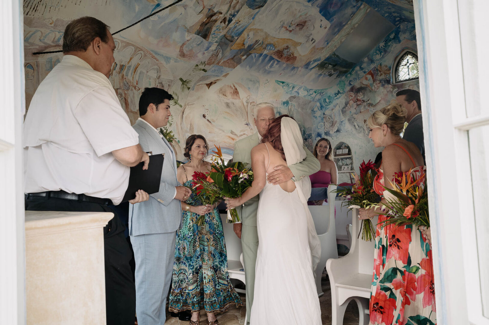Chapel on the Dunes Wedding | Port Aransas, Texas | Mady+Roland 29 Father of the brides gives away his daughter inside the chapel, painted mural ceiling above.