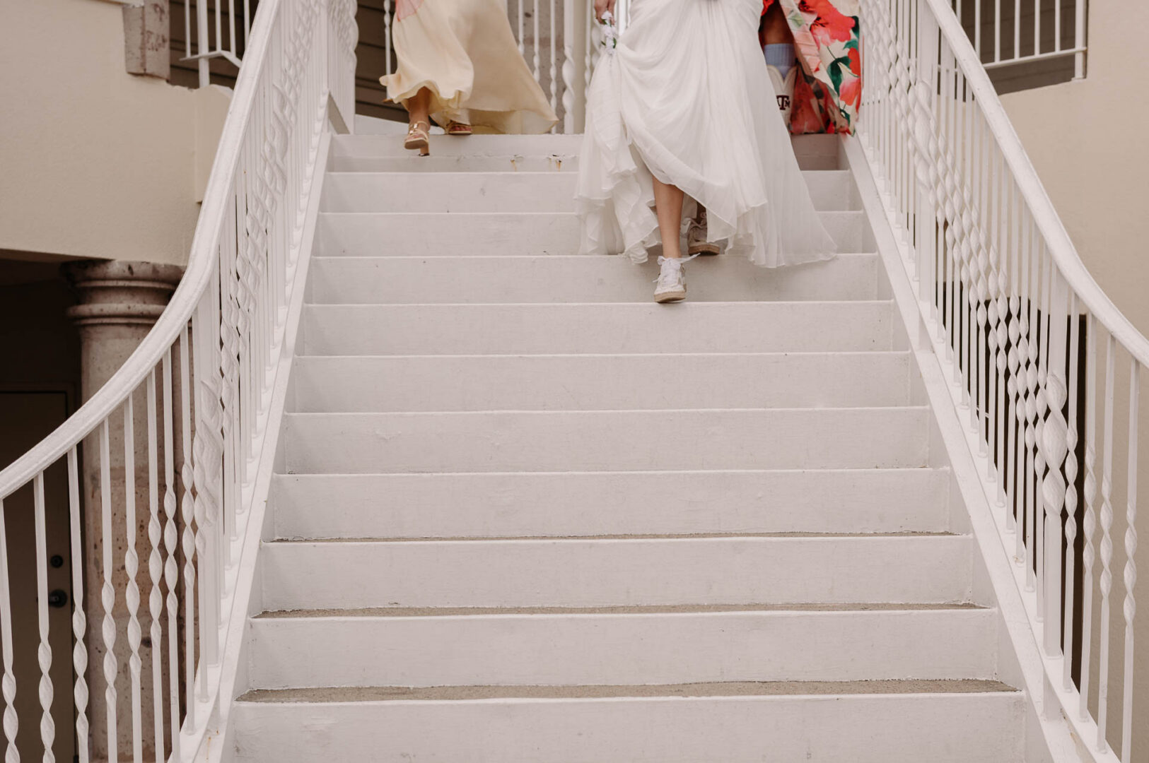 Chapel on the Dunes Wedding | Port Aransas, Texas | Mady+Roland 38 Close-up of feet on a staircase as the bride climbs the stairs, her dress trailing behind her.