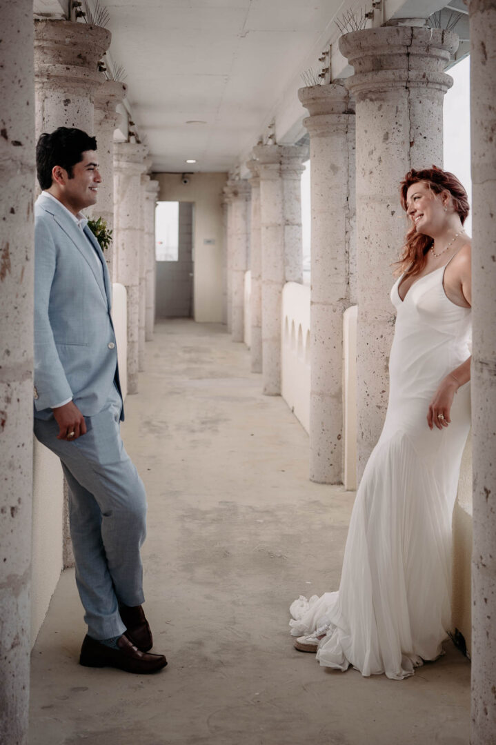 Chapel on the Dunes Wedding | Port Aransas, Texas | Mady+Roland 41 Close-up of the couple in a sunlit colonnade.