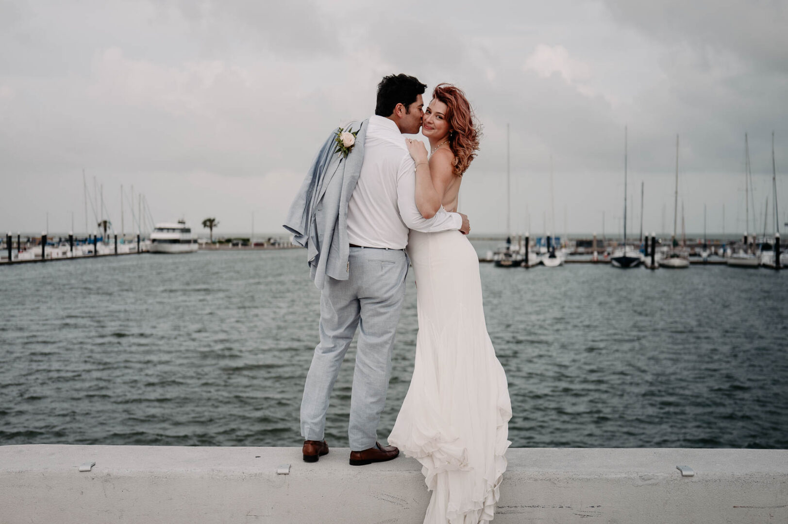 Chapel on the Dunes Wedding | Port Aransas, Texas | Mady+Roland 51 Couple embracing by the water.