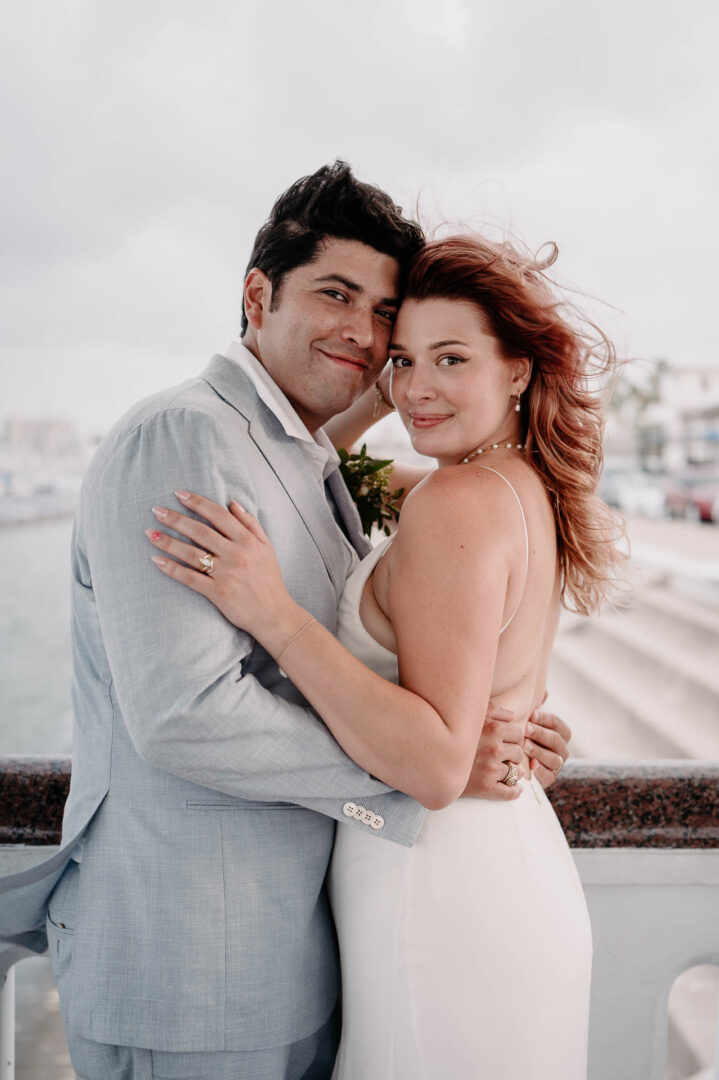 Chapel on the Dunes Wedding | Port Aransas, Texas | Mady+Roland 52 Couple embracing on a waterfront.