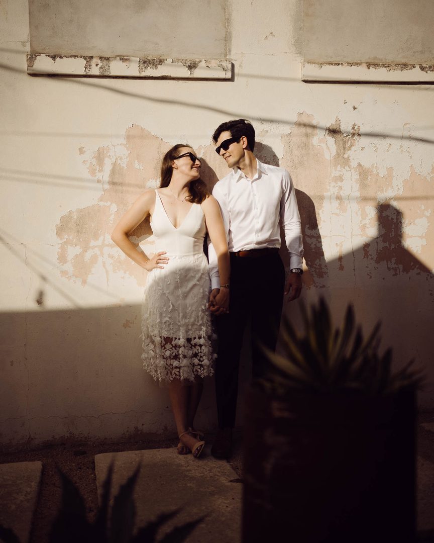 Couple holding hands against wall