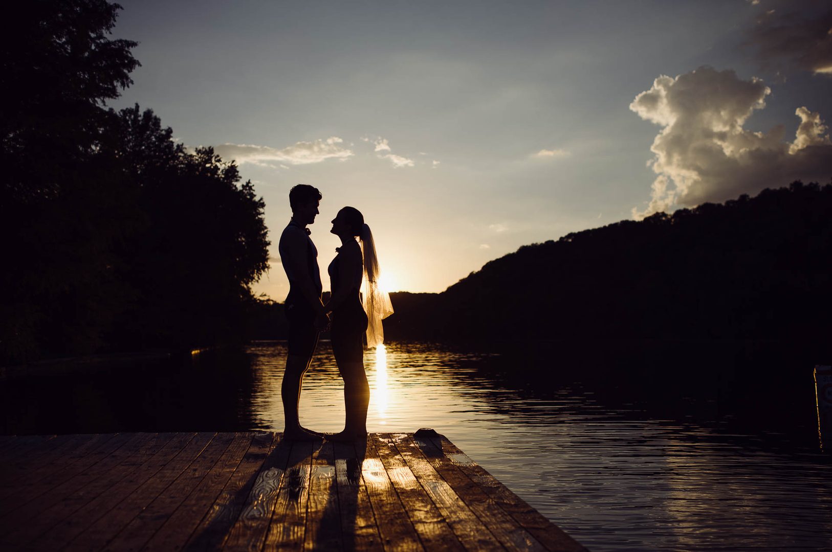 Silhouetted couple by sunset lake